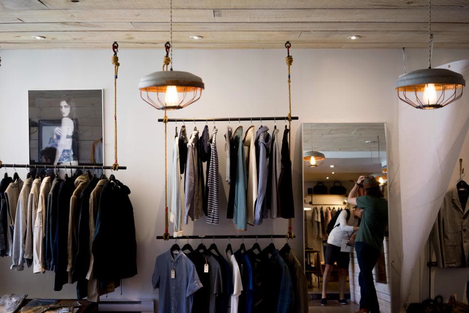 Boutique interior with garments on suspended rails under pendant lamps